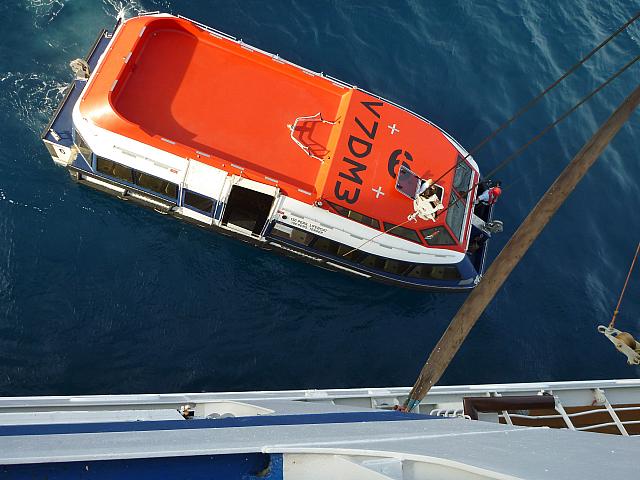 Hooking up the tender to lift it aboard the ship
